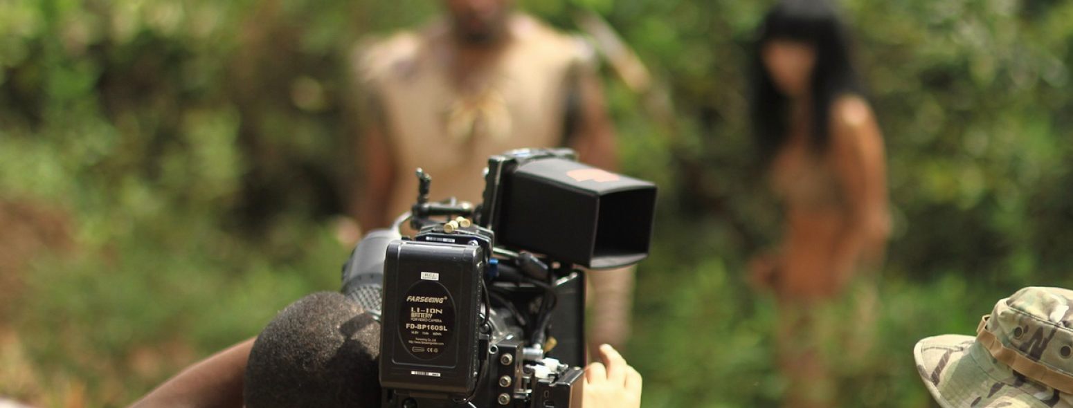 A camera operator checks framing on a monitor before a location shoot begins.